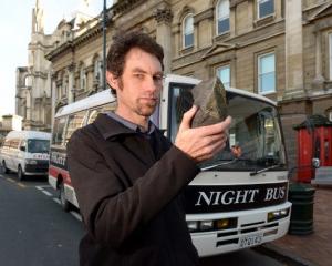 Night Bus Dunedin operator Andrew Rutherford with the rock he says was thrown through the window...