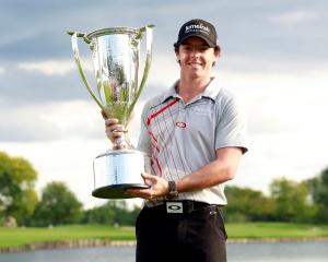 Northern Irish golfer Rory McIlroy poses with the champion's trophy after winning the PGA...