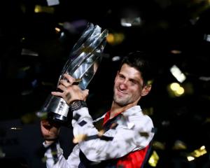 Novak Djokovic of Serbia celebrates with his trophy after winning the men's singles final against...