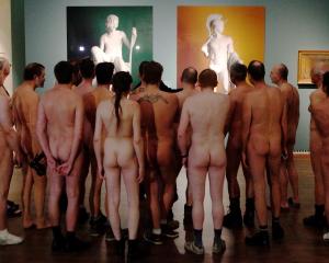 Nude visitors looks at the laserchrome prints 'Shepherd Boy' (L) and 'Jason' by Michael Elmgreen...