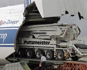 One of the world's largest concrete pumps is driven into the belly of a Russian Antonov AN-24...