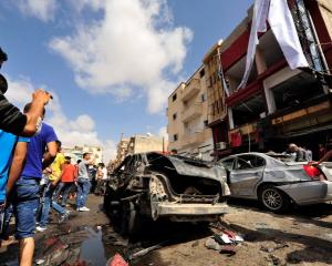 Onlookers take photographs following a car bomb explosion outside a hospital in Benghazi, Libya....