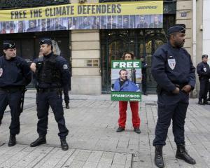 Police secure the area as Greenpeace activists protest in front of Gazprom headquarters in Paris....