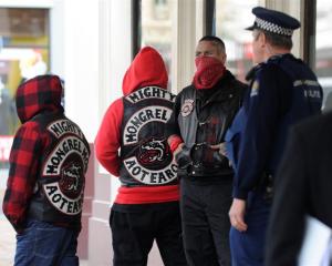 Police talk to people waiting outside the courthouse while Black Power and Mongrel Mob members...