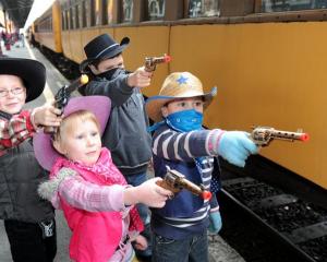 Practising their bandit apprehension skills before boarding the Taieri Gorge train yesterday are ...