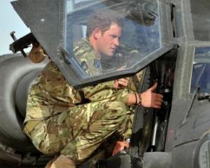 Prince Harry examines the cockpit of an Apache helicopter at Camp Bastion in Afghanistan at the...