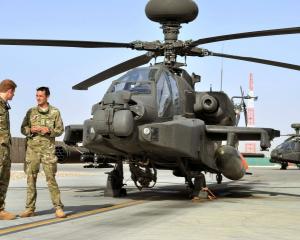 Prince Harry is shown the Apache helicopter flight line by an unidentified member of his squadron...