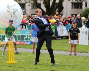 Prince William, Duke of Cambridge plays a game of cricket during a visit to Latimer Square in...