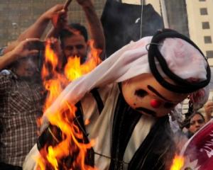 Protesters burn an effigy of Qatar's Emir Sheikh Hamad bin Khalifa al-Thaniat during a...