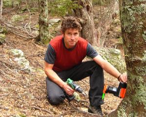 Queenstown Climbing Club committee member Philip Green installs a possum trap at Wye Creek, south...