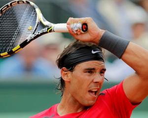 Rafael Nadal of Spain returns the ball to Denis Istomin of Uzbekistan during their match at the...