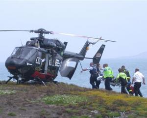 Rescuers carry an ill Kakanui man to the Otago Regional Rescue Helicopter on the island at the...