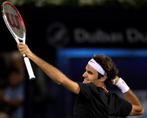 Roger Federer of Switzerland celebrates after beating Andy Murray of Britain to win the Dubai...