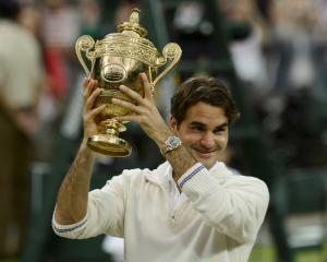 Roger Federer of Switzerland holds the winners trophy after defeating Andy Murray of Britain in...