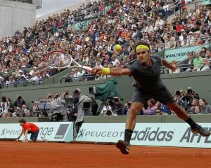 Roger Federer of Switzerland returns the ball to David Goffin of Belgium during the French Open...