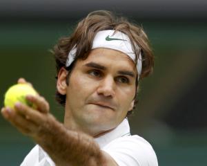 Roger Federer of Switzerland serves to Fabio Fognini of Italy during their men's singles match at...