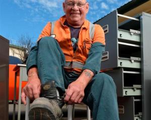 Roger Parsons removes his work boots for the last time yesterday,  signalling his retirement...