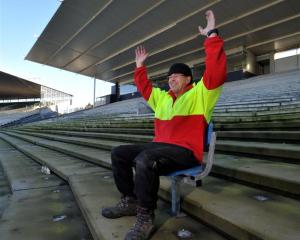 Rotarian Brendan Bearman tries out one of the last seats left in the Railway Stand at Carisbrook...