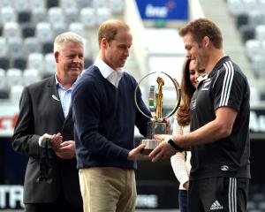 Prince William presents the IRB World Trophy to McCaw while watched by NZ Rugby chief executive...