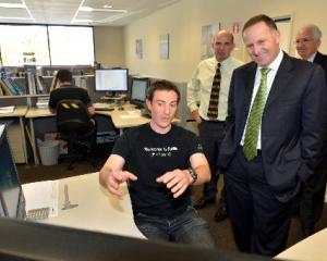 Scott Technology engineer Mike Diment shows Prime Minister John Key what he is working on, while...