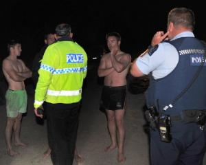 Search and rescue co-ordinator Senior Sergeant Brian Benn (centre) talks to three young men who...