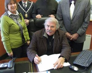 Signing a trust deed this week are Hearts and Hands for Haiti trustees Bruce Albiston (seated,...