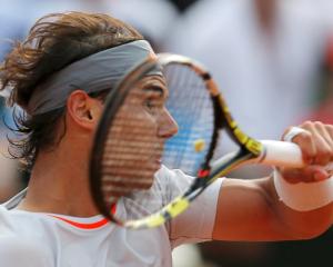 Spain's Rafael Nadal hits a return to Stanislas Wawrinka of Switzerland during their men's...