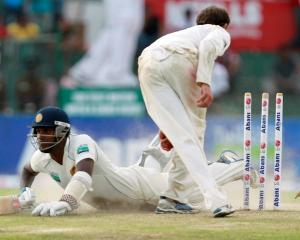 Sri Lanka's Angelo Mathews dives to complete a run as Australia's Nathan Lyon breaks the wickets...