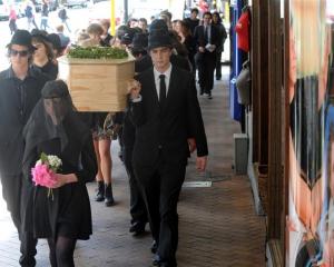 Students and environmentalists carry a coffin through Dunedin to raise awareness of environmental...