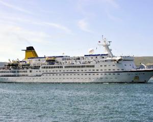 The cruise ship Spirit of Adventure, accompanied by tug Otago, heading up the channel toward Port...