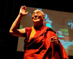 The Dalai Lama acknowledges a standing ovation at the start of his Dunedin Town Hall talk. Photo...