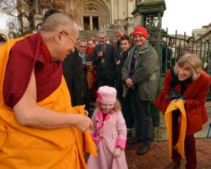 The Dalai Lama greets a young girl in front of St Paul's Cathedral.