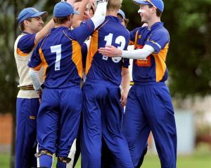 The excited bowler, Jack Hunter (shirt No 13), celebrates with his team-mates. Photos by Craig...