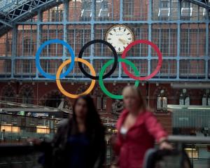 The Olympic Rings are seen as commuters walk in St Pancras Station, home of the Eurostar, in...