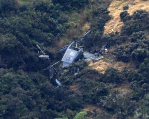 The wreckage of the Royal New Zealand Air Force Iroquois helicopter on the side of a hill in...