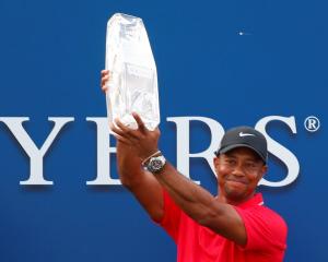 Tiger Woods holds up the trophy after winning the PGA Players Championship golf tournament at TPC...