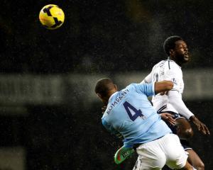 Tottenham Hotspur's Emmanuel Adebayor (R) is challenged by Manchester City's Vincent Kompany....