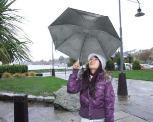 Tourist Sienna Chin, of Taiwan, shelters under her umbrella at Lake Wanaka. Photo by Matthew...