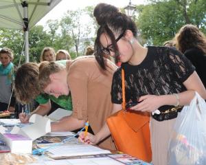 University of Otago students (from right) Anh Hoang and Kimberley Houliston sign a petition...