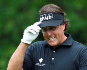 US golfer Phil Mickelson reacts to applause after hitting his tee shot on the 11th hole during...