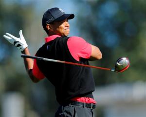 US golfer Tiger Woods lets go of his driver on his follow through while hitting off the 9th tee...