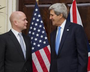 US Secretary of State John Kerry (R) talks with British Foreign Secretary William Hague at...