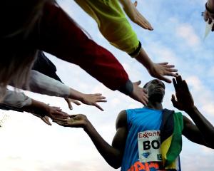 Usain Bolt of Jamaica celebrates with members of the crowd after winning the men's 100m during...