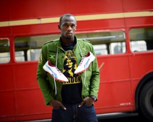 Usain Bolt of Jamaica poses beside a traditional routemaster bus outside the British Museum in...