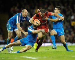 Wales' Jamie Roberts (C) is caught by the Italian defence. REUTERS/Rebecca Naden