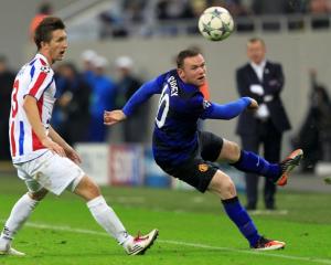 Wayne Rooney (R) of Manchester United is challenged by Cornel Rapa of Otelul Galati during their...