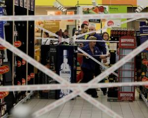 Workers puts tape to close an aisle with hard liquor in a supermarket in Prague. REUTERS/David W...