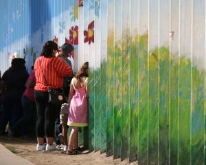 People talk to relatives at the border wall  dividing the US and Mexico in Tijuana. Photo: Reuters