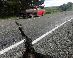 A truck drives over the fractured road caused by an earthquake south of the town of Ward. REUTERS...