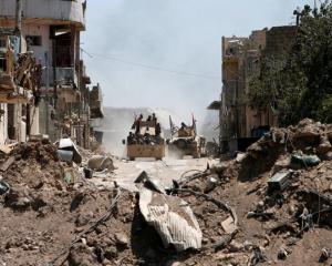 Displaced people who flee from the clashes ride in military vehicle of Iraqi security forces. Photo: Reuters